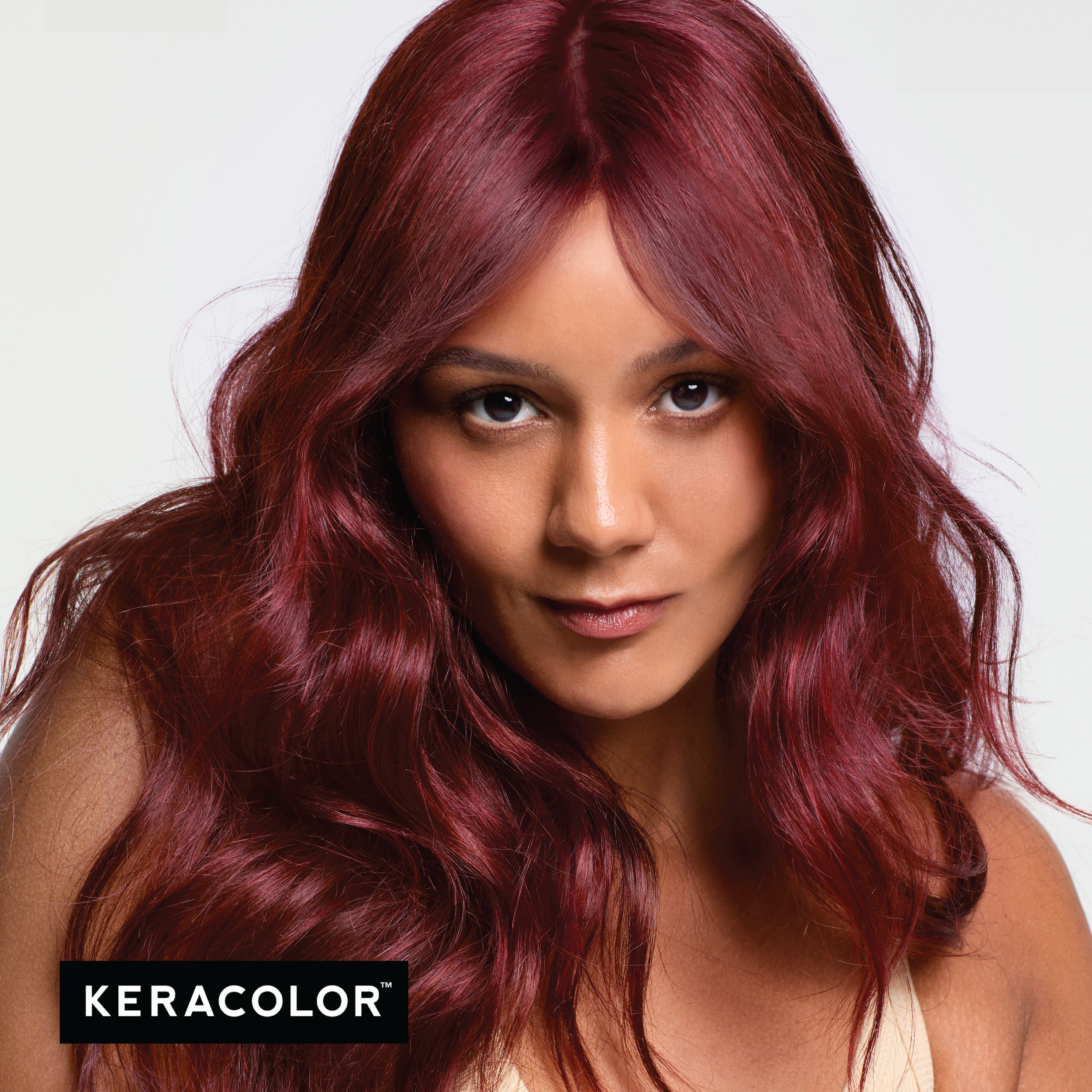 Woman with vibrant red hair against a white background, featuring the Keracolor logo.